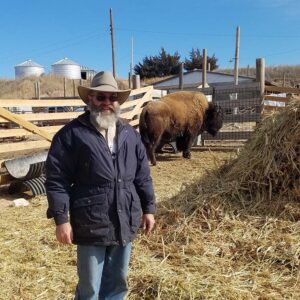 Rex Moore in a pen with a bison.